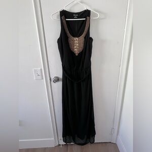 City chic sleeveless dress with gold accessory detail. Waist tie included